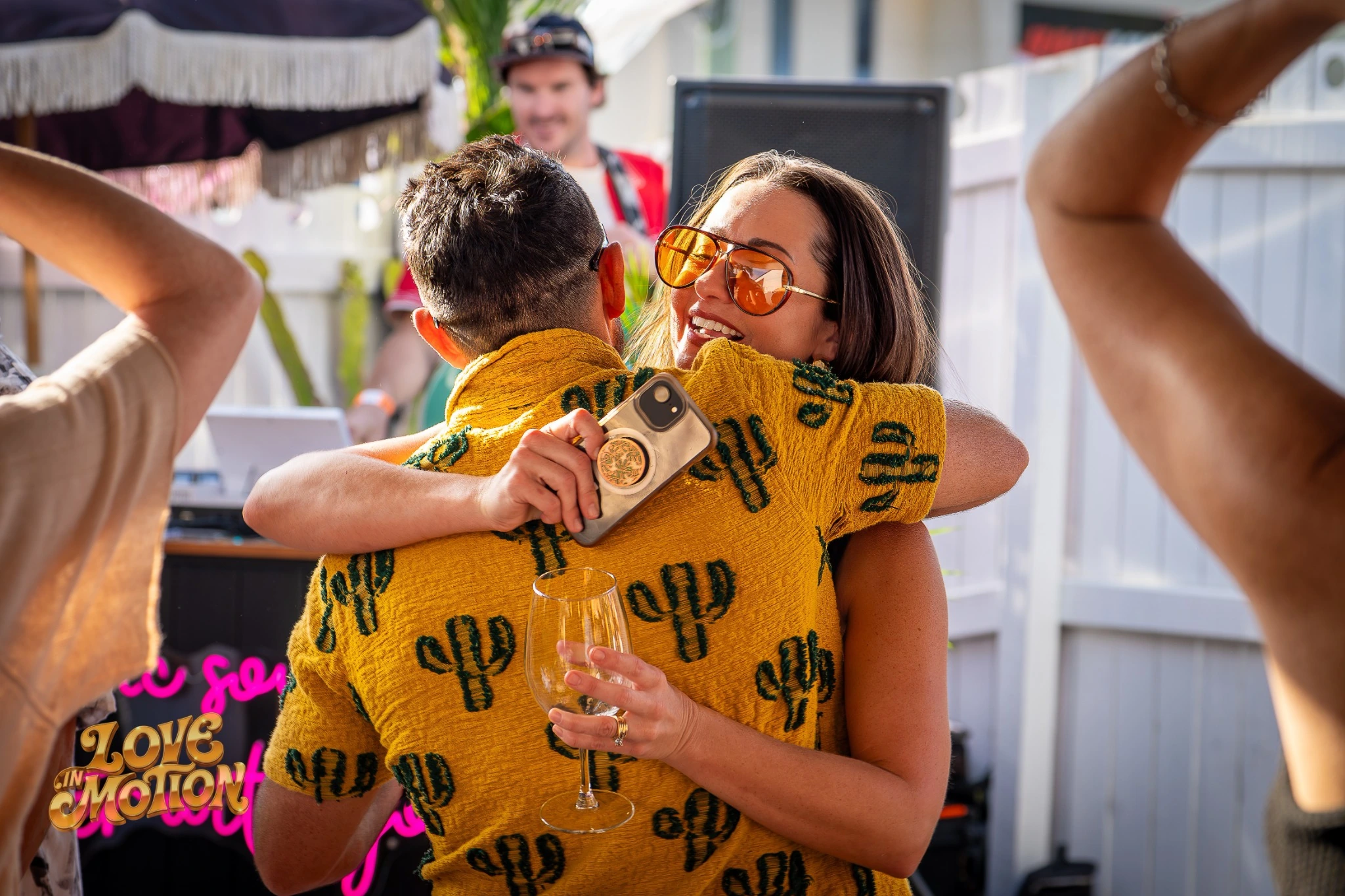 Two people embracing in matching yellow cactus shirts at Love in Motion